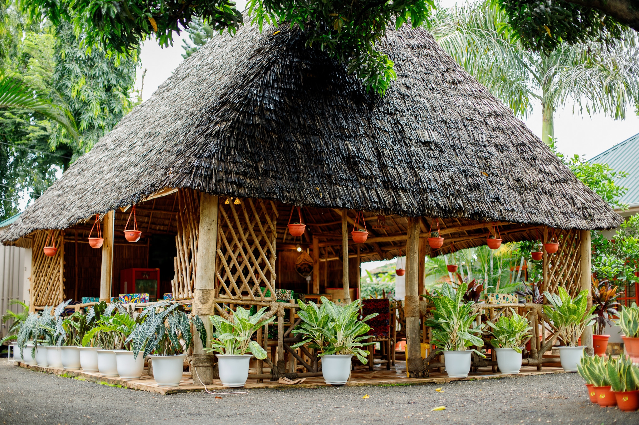 Large traditional thatched-roof restaurant with extensive seating and lush plant decoration